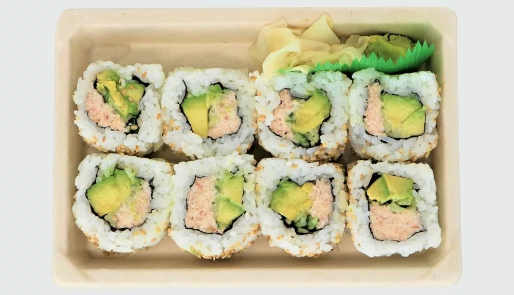 8 pieces of california roll sushi with crab, avocado in rice with pickled ginger and wasabi in tray