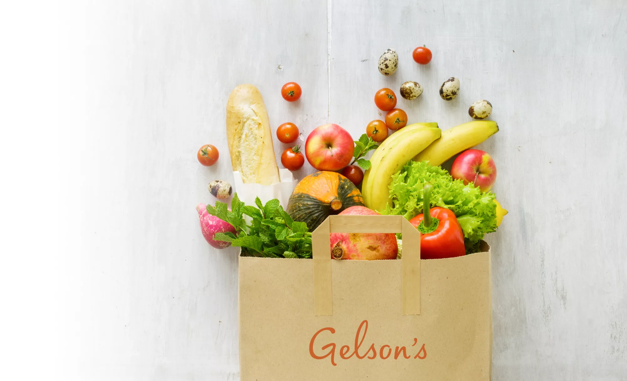 Grocery bag with Gelson's logo filled with fresh fruit and vegetables